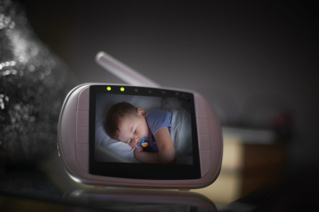Baby monitor on bedside table in the bedroom with the image of the baby