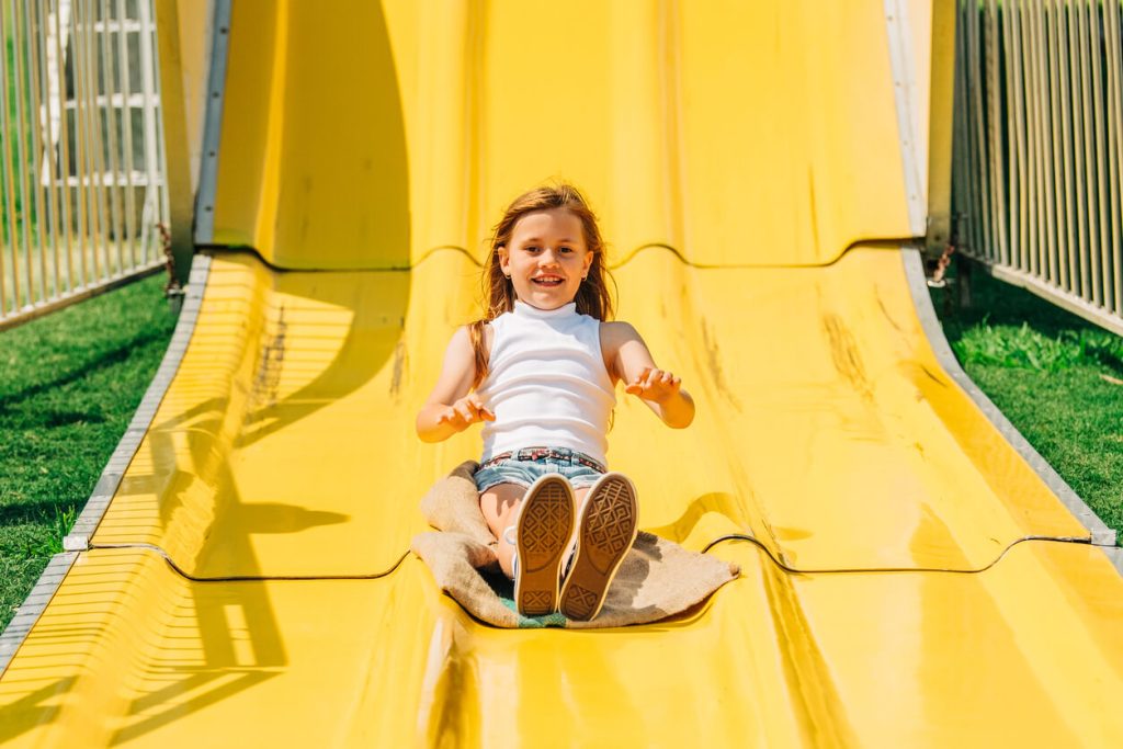 A little girl going down a big slide