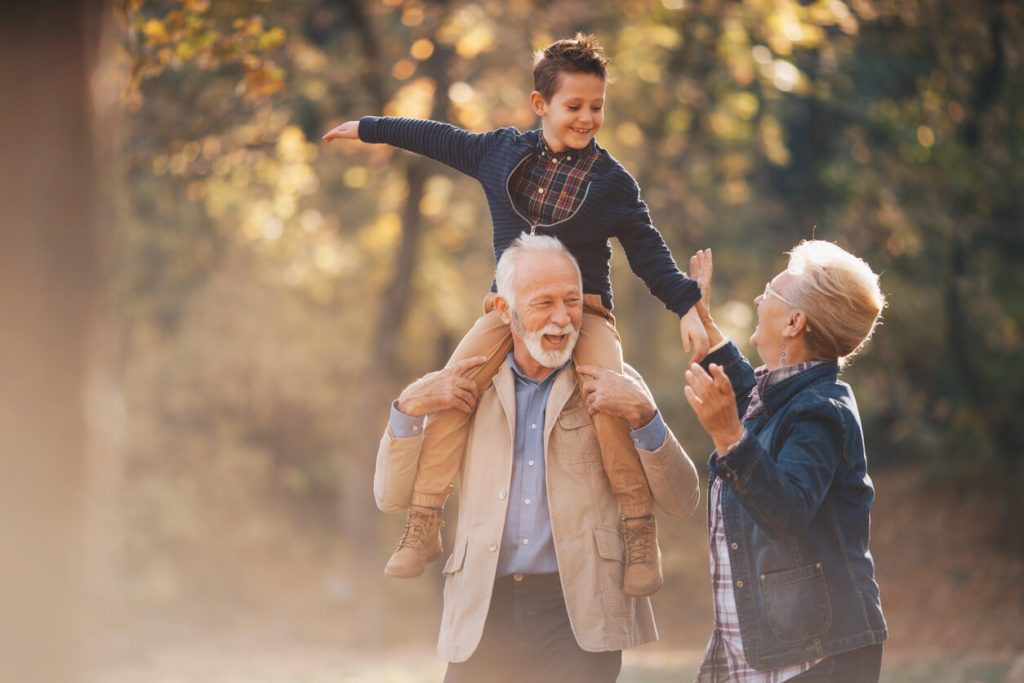 grandparents with their grandson during fall